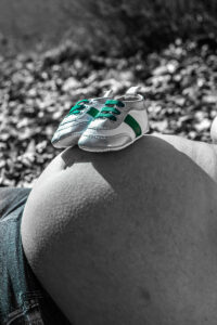 Babyschuhe auf Babybauch
