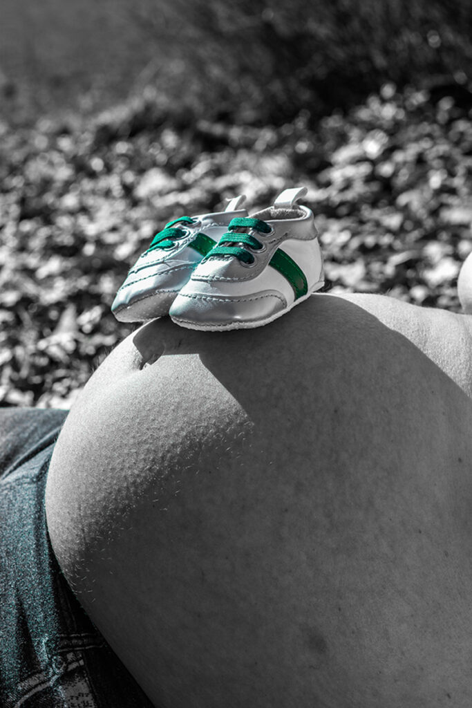 Babyschuhe auf Babybauch